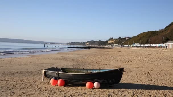 Bateau à rames en bois unique sur une plage de sable fin au Royaume-Uni avec bouées et aides à la flottaison — Video