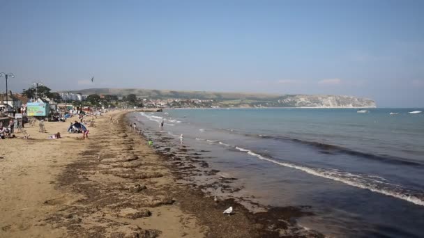 Playa de Swanage Dorset Inglaterra Reino Unido con olas en la orilla cerca de Poole y Bournemouth en el extremo oriental de la Costa Jurásica un destino turístico de costa sur popular Patrimonio de la Humanidad — Vídeo de stock