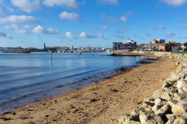 Poole harbour ve quay Dorset İngiltere İngiltere deniz ve kum ile doğru mavi gökyüzü ve beyaz bulutlar ile güzel bir gün görüntüleyin