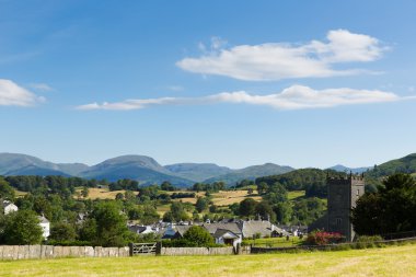Güzel Hawkshead köy Lake District Cumbria İngiltere'de yaz mavi gökyüzü kilise ve kırmızı gül