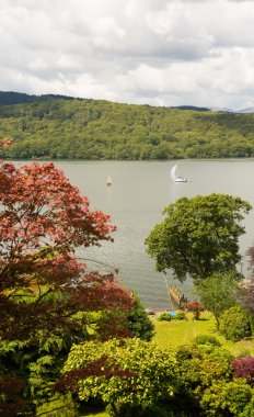 Yelkenli teknelerde Windermere Gölü Bölgesi Cumbria İngiltere güzel huzurlu dinlendirici yaz gününde renkli kırmızı ve kahverengi ağaçları ile