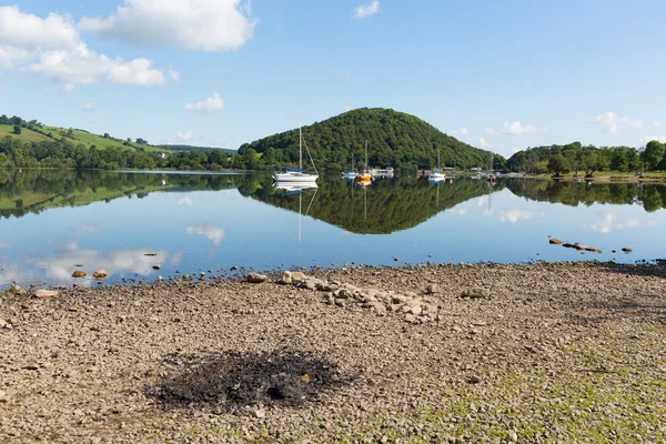 Cenizas de barbacoa junto al hermoso lago en la tranquila mañana idílica de verano con reflejos de nubes — Foto de Stock