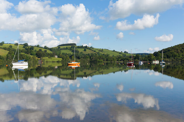 Озерный округ - популярное место отдыха в Великобритании летом с лодками, голубым небом и облаками.
