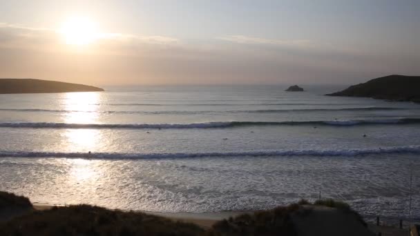 Coucher de soleil en Cornouailles avec les surfeurs surfant encore le soir de printemps dans la baie de Crantock et la plage Cornouailles du Nord Angleterre Royaume-Uni près de Newquay — Video