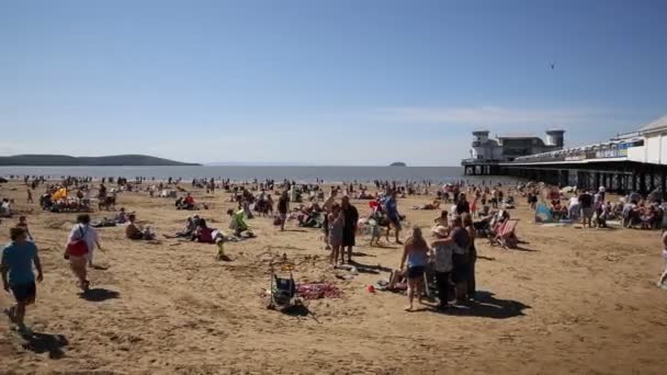 Weston-super-Mare beach and pier Somerset with tourists and visitors enjoying the summer sun PAN view — Stock Video