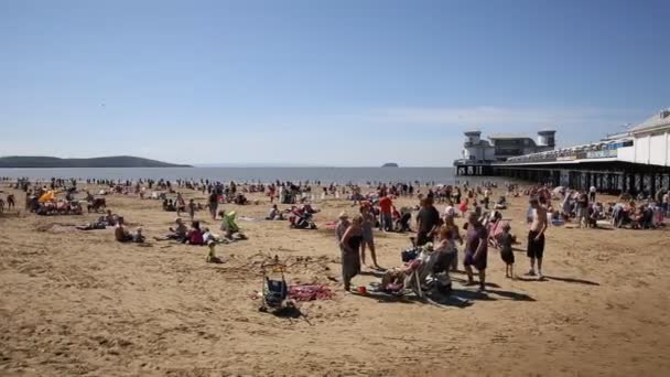 English summer scene Weston-super-Mare beach and pier Somerset with tourists and visitors enjoying the summer sun PAN — Stock Video