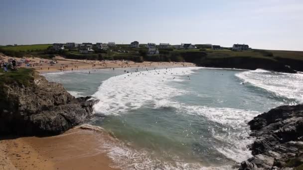 Treyarnon Bay Cornwall Anglii Uk pływaków w surf i fale na wybrzeżu Północnej Kornwalii pomiędzy Newquay i Padstow na słoneczne lato niebieski niebo dzień — Wideo stockowe