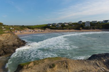 Yüzücüler sörf ve dalgalar Treyarnon Bay Cornwall İngiltere'de İngiltere'de Cornish kuzey kıyılarında Newquay ve Padstow arasında mavi gökyüzü gün güneşli yaz