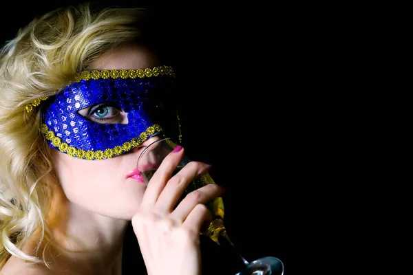 Woman in carnival mask drinks champagne., new Year party
