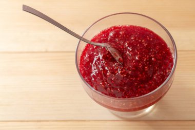 Ahşap zemin üzerinde şekerli ahududu reçeli.