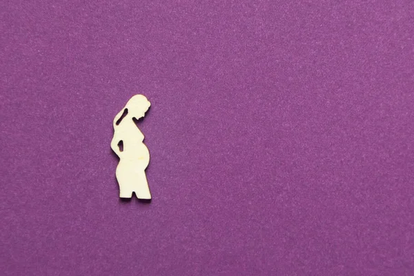 Mor arka planda hamile bir kadının silüeti..