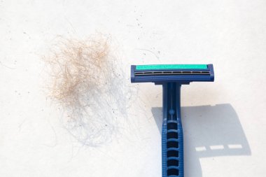 Mavi erkek jileti ve beyaz bir arka planda tıraş olmuş bir dağ..