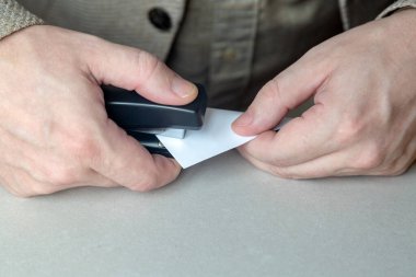 İşçi kağıtlarını masaya zımbalar. Kapatın.