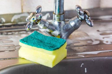 Mutfak lavabosunda sünger ve köpük solüsyonu var. Temizlik kavramı.