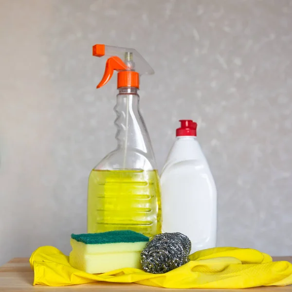 Bottled cleaning agent and dishwashing set are on the table.