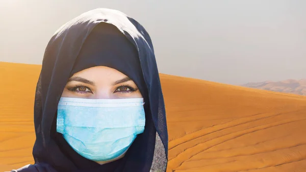 Muslim woman in the desert sands. Close-up.