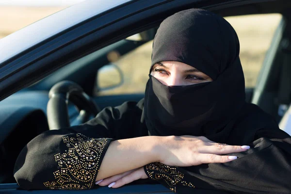 Muslim woman waiting in line in traffic jam.