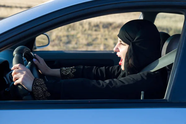 Woman screaming singing songs while driving a car.,