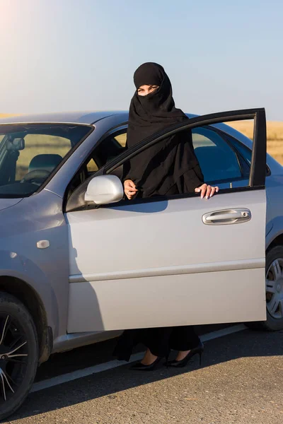 Muslim woman travel by car. Traditional clothing.