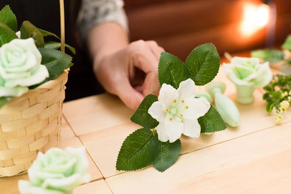 Handmade soap in the shape of a flower in a woman\'s hand.