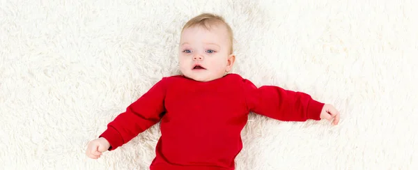 Kırmızı Elbiseli Beyaz Bebek Sırt Üstü Yatıyor — Stok fotoğraf