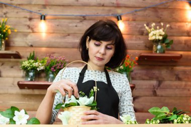 Çiçekçi dekoratörünün işyeri. Buket toplayan kadın.