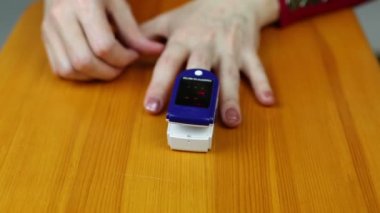 Oximeter on the finger woman's hand, reading oxygen in human blood.