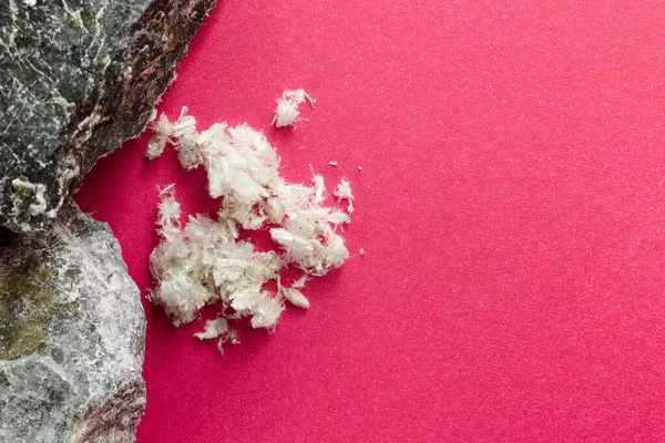 Kırmızı arka planda, mineral taşlarının yanında asbest lifleri var. Boşluğu kopyala