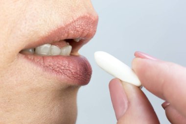 Adam ağzına sakız getiriyor, parmakları ve dudakları yakın plan..