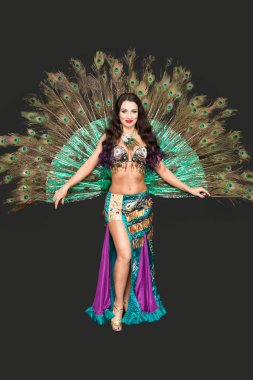 Yemyeşil tavus kuşu tüylerinden yapılmış dans kıyafeti, siyah arka plan.