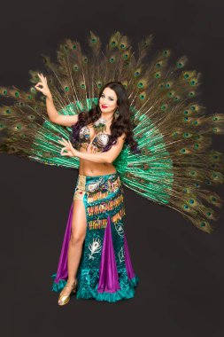 Yemyeşil tavus kuşu tüylerinden yapılmış dans kıyafetleri siyah arka plan.