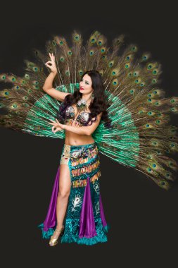 Siyah arka planda kuş tüylerinden oluşan lüks bir kıyafetle ulusal dansçı..