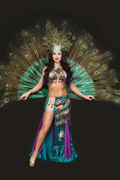 Siyah arka planda kuş tüylerinden oluşan lüks bir elbiseyle ulusal dansçı.