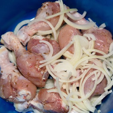 Çiğ tavuk, doğranmış soğan ve baharatla kaplanmış..