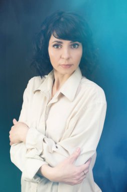 Güzel esmer, kısa saçlı, yakın plan, mavi arka plan.