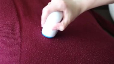 Kadın giysilerdeki yünleri kesiyor..