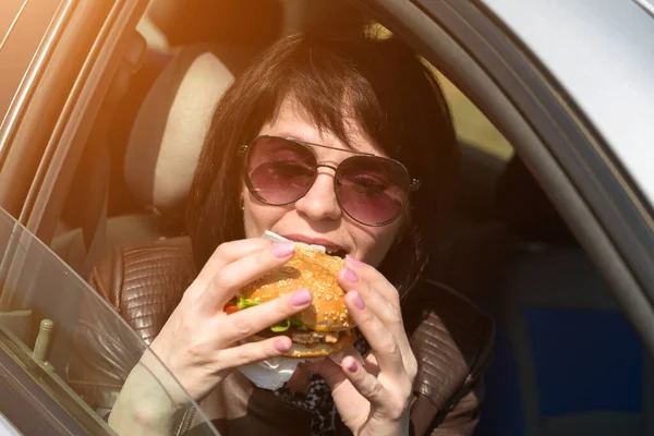 Szczęśliwa Młoda Kobieta Jedząca Lunch Samochodzie Okulary Słoneczne — Zdjęcie stockowe