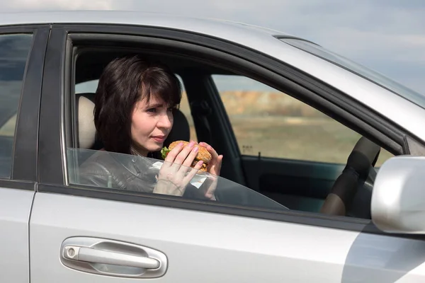 Kobieta Fast Food Kierownicą Koncepcja Złego Odżywiania Współczesnym Społeczeństwie — Zdjęcie stockowe