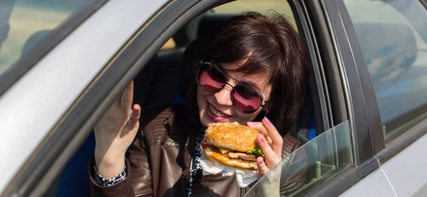 Egy Aki Hamburgerrel Kezében Autót Vezet — Stock Fotó