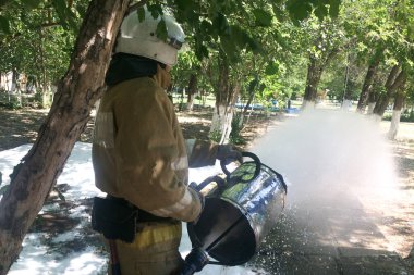İtfaiyeci hortumdan köpük salıyor..