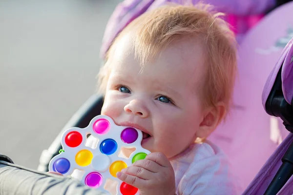 Uma Criança Sorridente Uma Carruagem Bebê Com Brinquedo Brilhante Uma — Fotografia de Stock