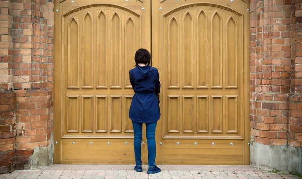 Женщина Стоит Перед Огромными Воротами Католической Церкви Пытаясь Открыть Дверь — стоковое фото