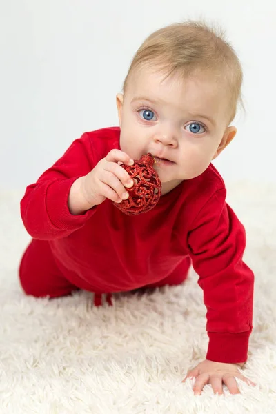 Маленький Ребенок Красном Костюме Белом Фоне Рождественской Игрушкой Зубах — стоковое фото