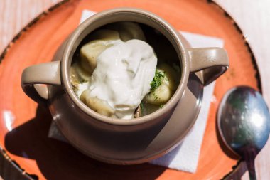 Açık bir kafedeki masada üzerinde Sibirya hamur tatlısı ve ekşi krema olan derin bir tabak..