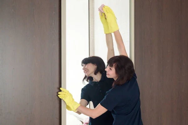여자가 구석으로 가려고 발끝으로 아파트에서 거울을 닦는다 — 스톡 사진
