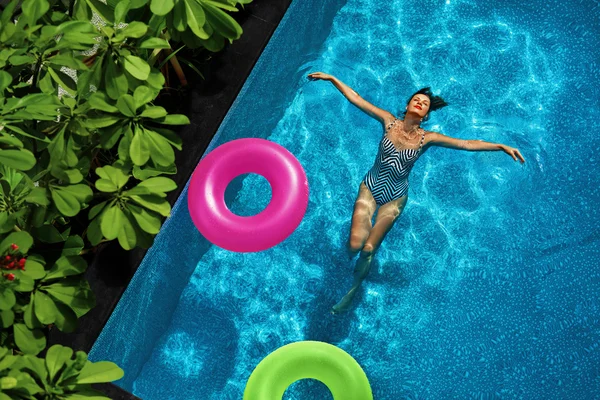 Vacaciones de verano. Mujer disfrutando de vacaciones, flotando en la piscina — Foto de Stock