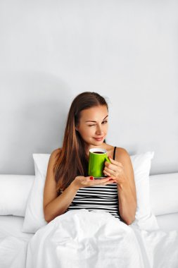 Sabah kahve içmek. Yatakta kadın içki içecek. Sağlıklı