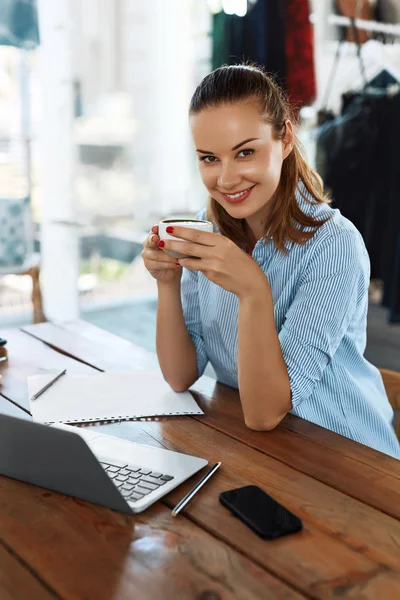 Бізнес-ланч. Здорова усміхнена жінка їсть суп, працює на комп'ютері — стокове фото