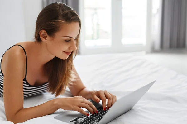 Mulher Compras Online. Sorrindo menina usando computador portátil em casa — Fotografia de Stock