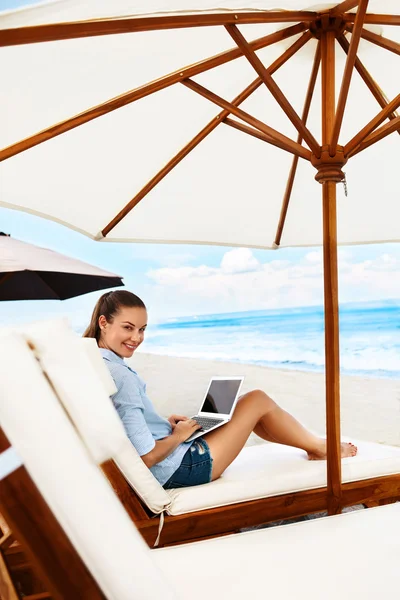 Žena, relaxační, používat počítač na pláži. — Stock fotografie
